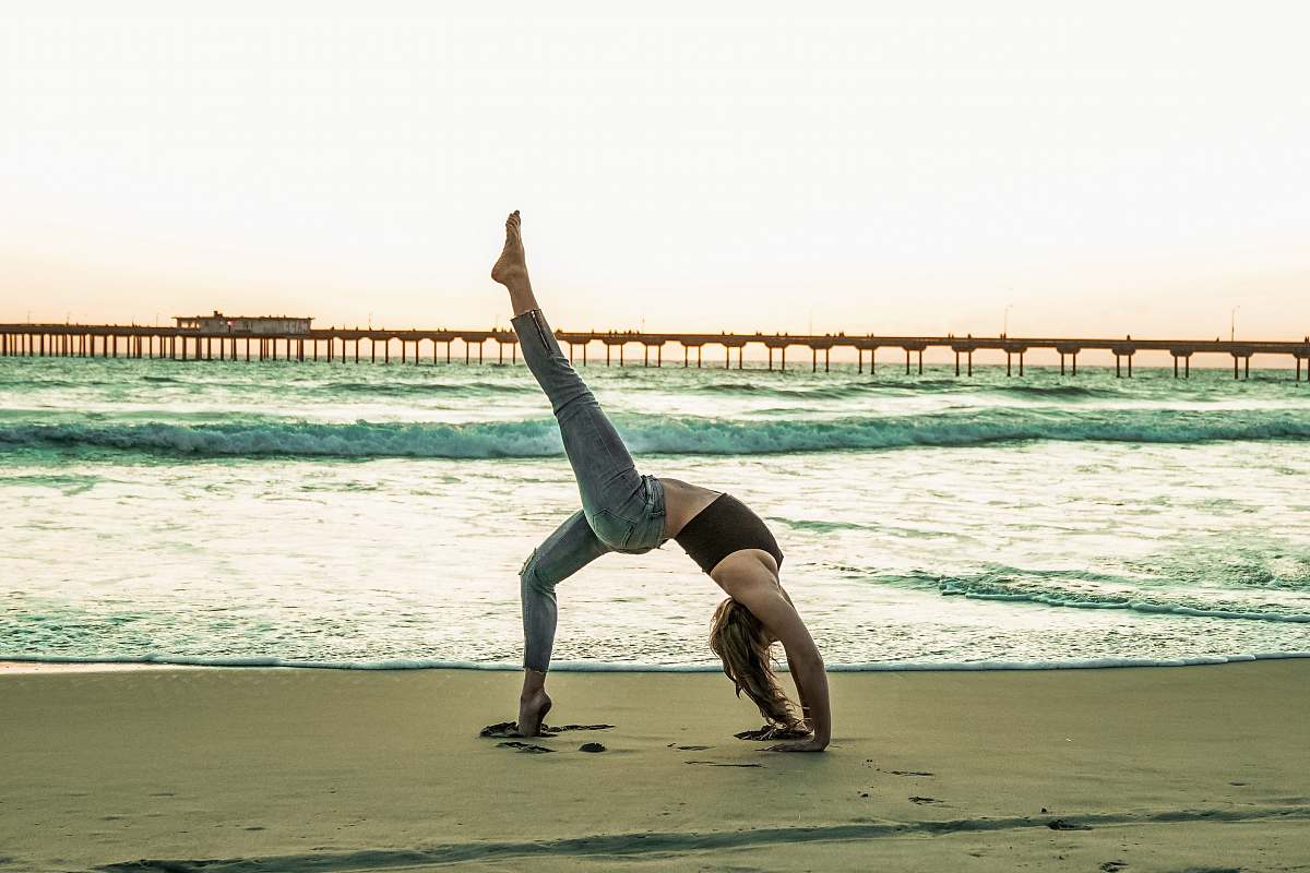 fitness woman doing yoga pose on seashore sport